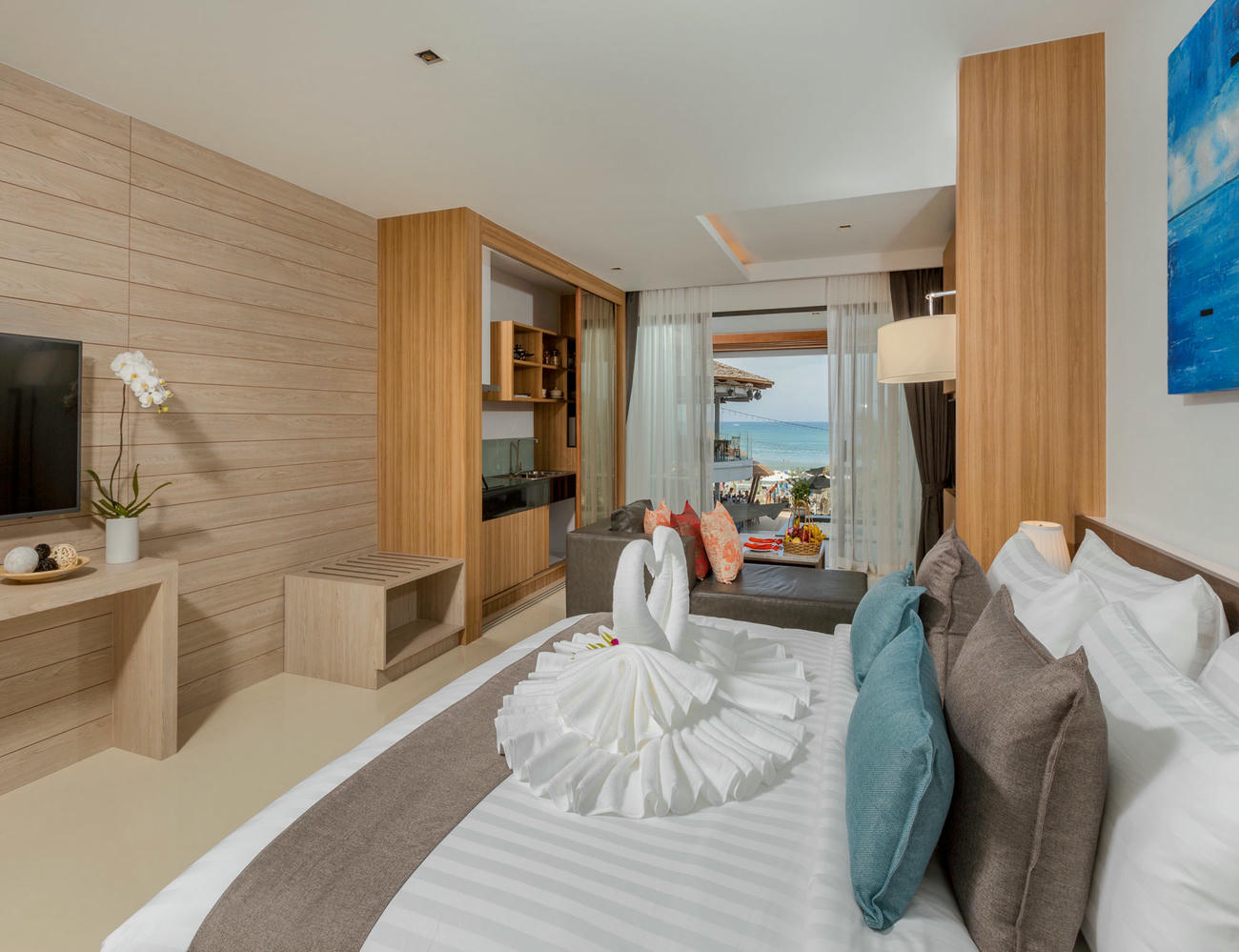 Deluxe Twin Room with a view of the beach through large windows, filling the space with natural light