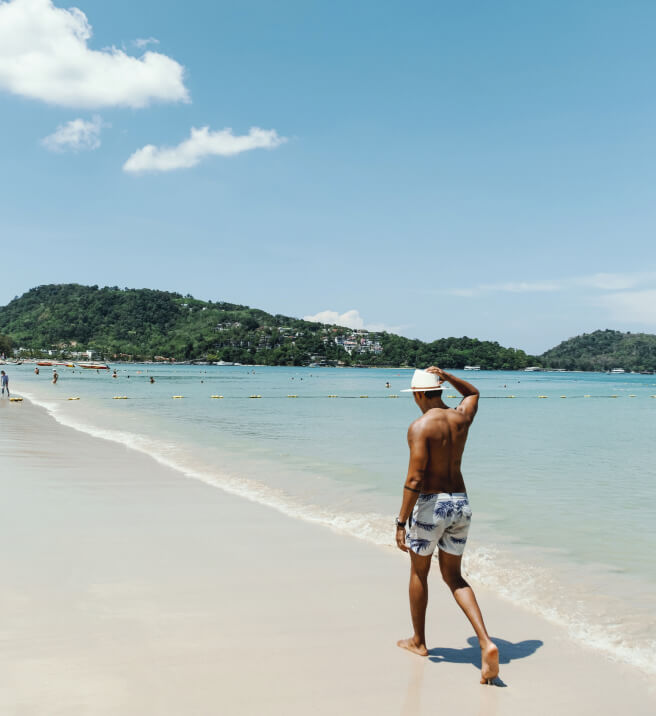 Man walking on the beach enjoying a relaxing stay, part of Kudo Hotel’s Advance Purchase special with discounted accommodation and perks