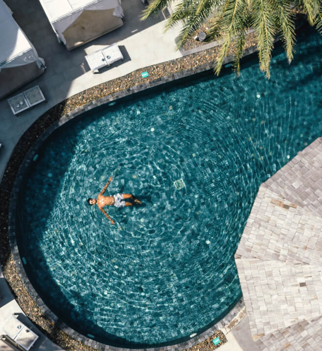 Man relaxing and floating in the pool at Kudo Hotel, enjoying the benefits of the Flash Sale Special